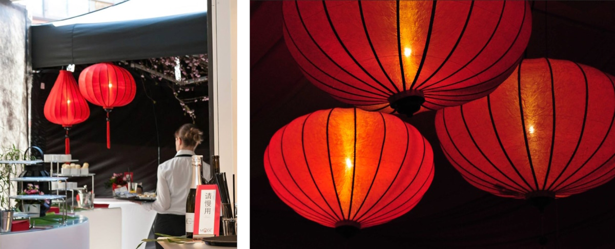 Twee rode lampionnen hangen boven een Japanse bar waar een bedieningsmedewerker langs loopt